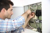 Electrician fixing cable in domestic electrical box